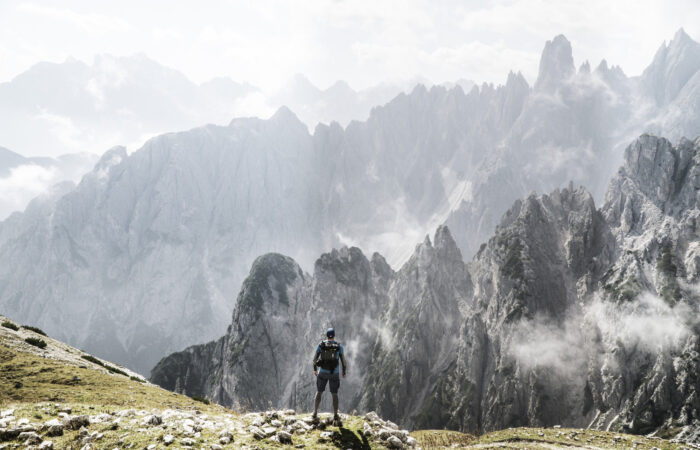 Excursionista con una mochila disfrutando de una vista de montaña brumosa